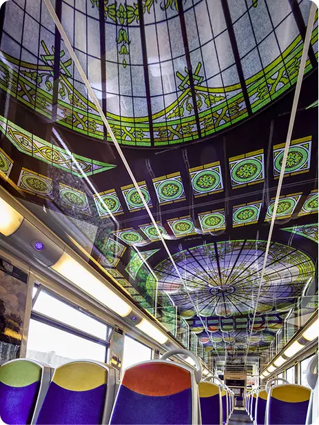 Stained-glass ceiling above a row of coloured seats