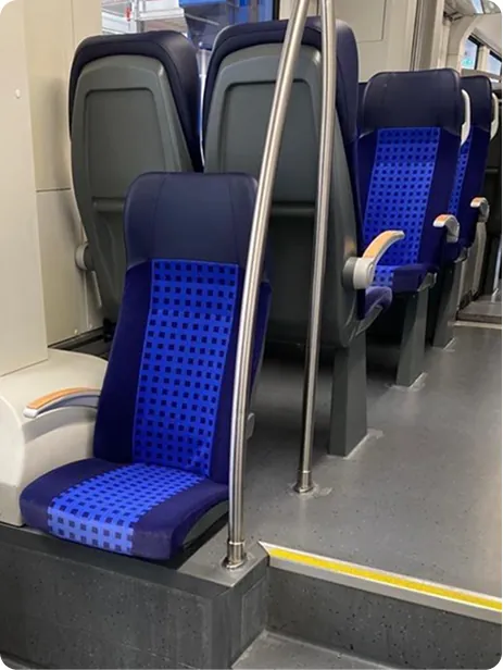 Blue seat module beside a stainless steel grab pole
